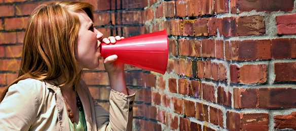 A rare photo of a real-life Facebook argument - (woman yelling at brick wall)